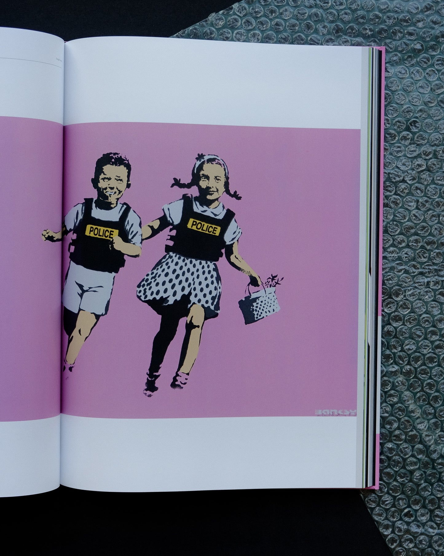 Interior page of the 'Laugh Now' catalogue, offering insights into Banksy's artistry and social commentary.