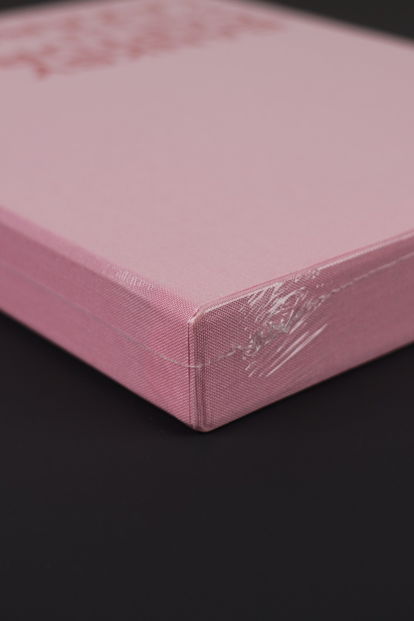 Close-up of the top corner of Banksy Captured Volume 2 slipcase, showing the pink fabric texture.