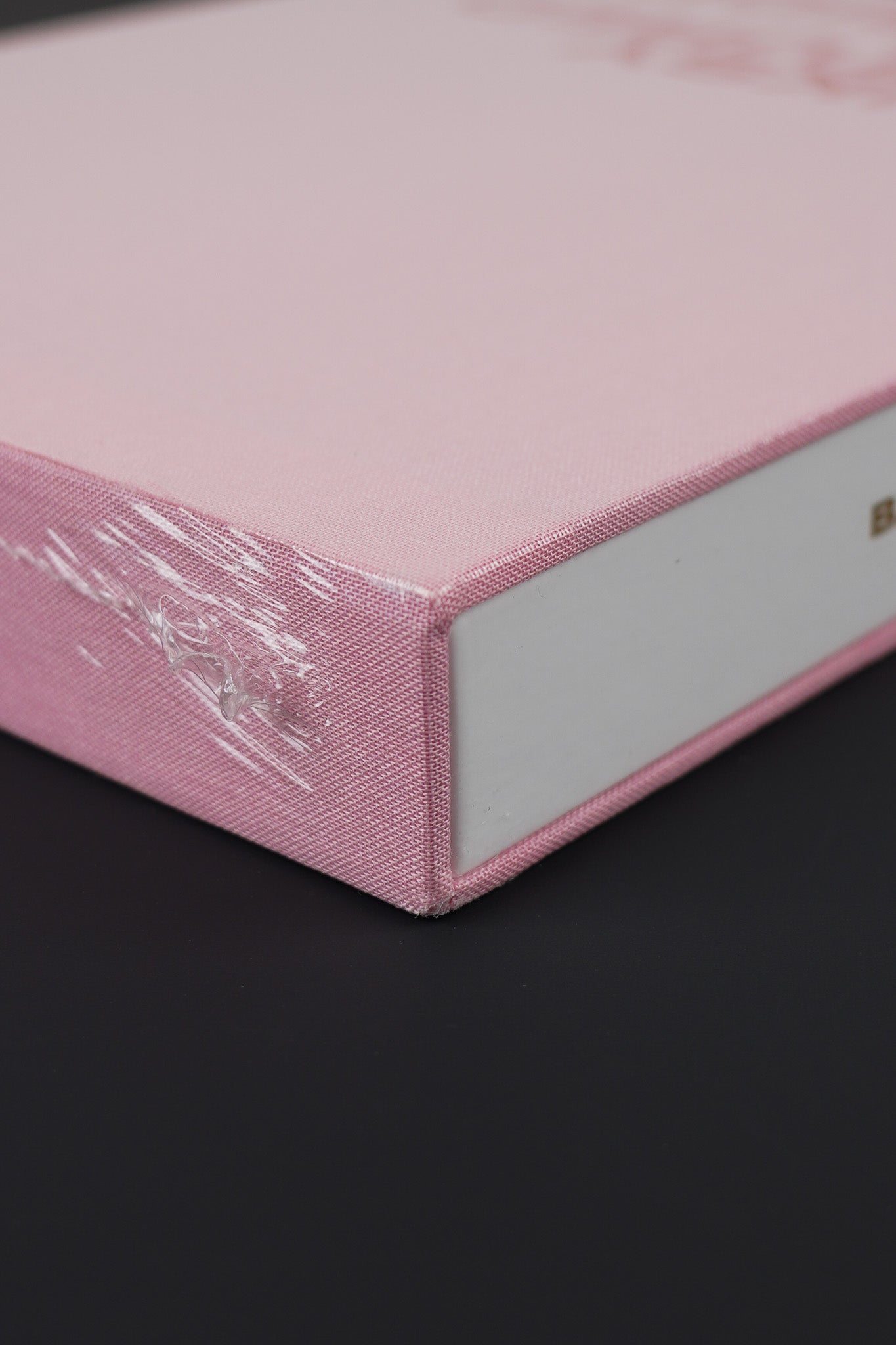 Close-up of the top corner of Banksy Captured Volume 2 slipcase, showing the pink fabric texture.