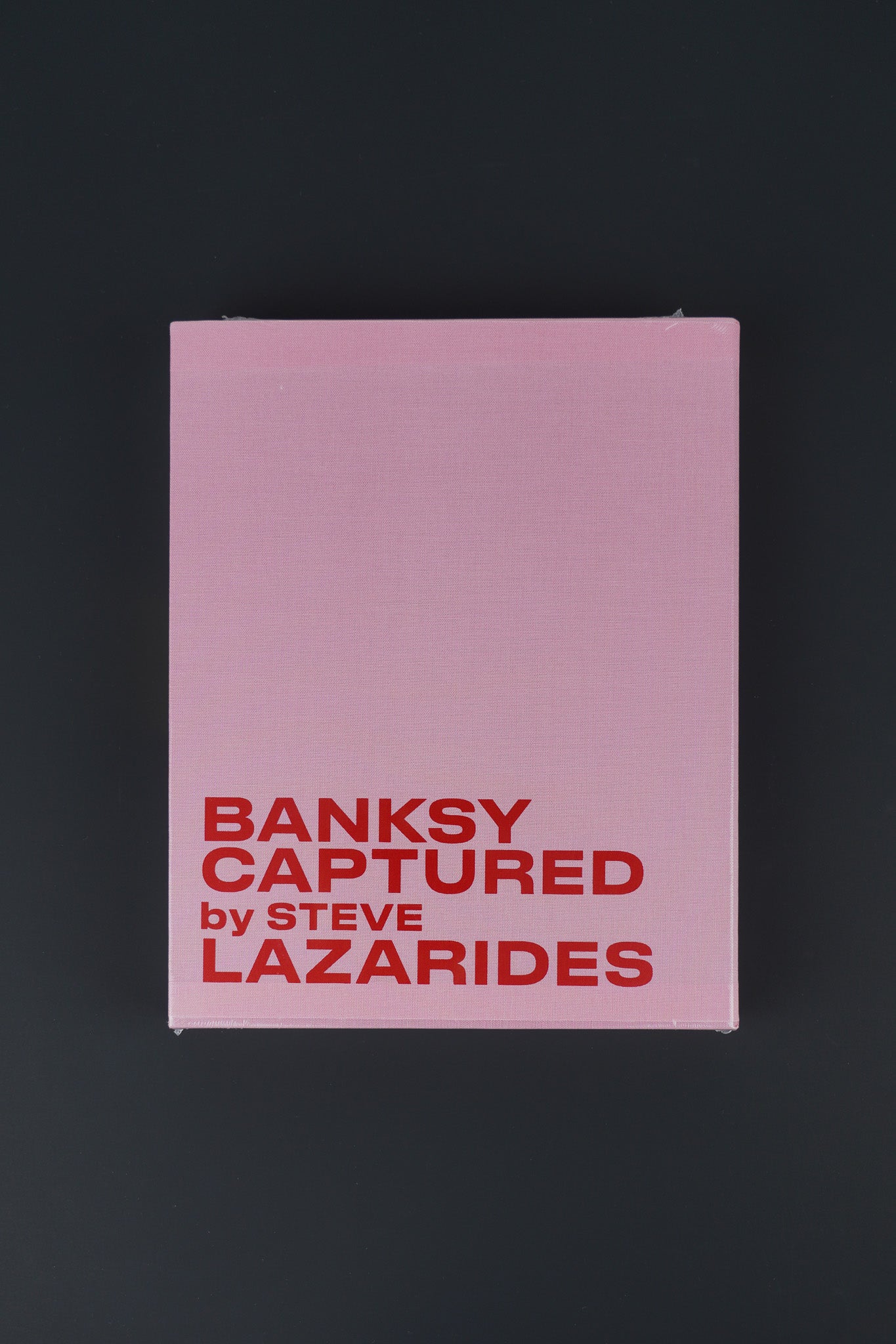 Limited edition Banksy Captured Volume 2 in a pink slipcover and hardcover design, sealed, showcasing its bold and vibrant aesthetic.