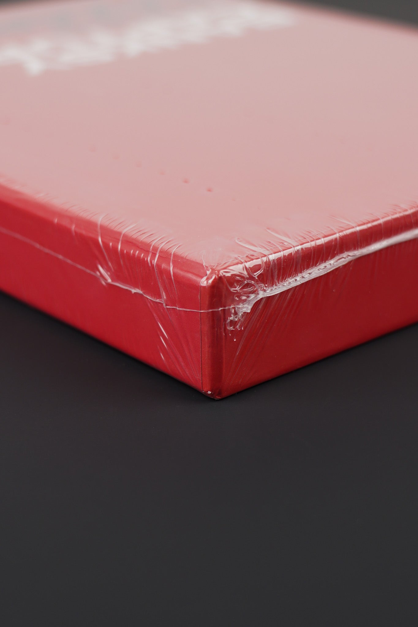 Detailed view of the upper corner of the sealed Banksy Captured red edition, showcasing slipcase texture.