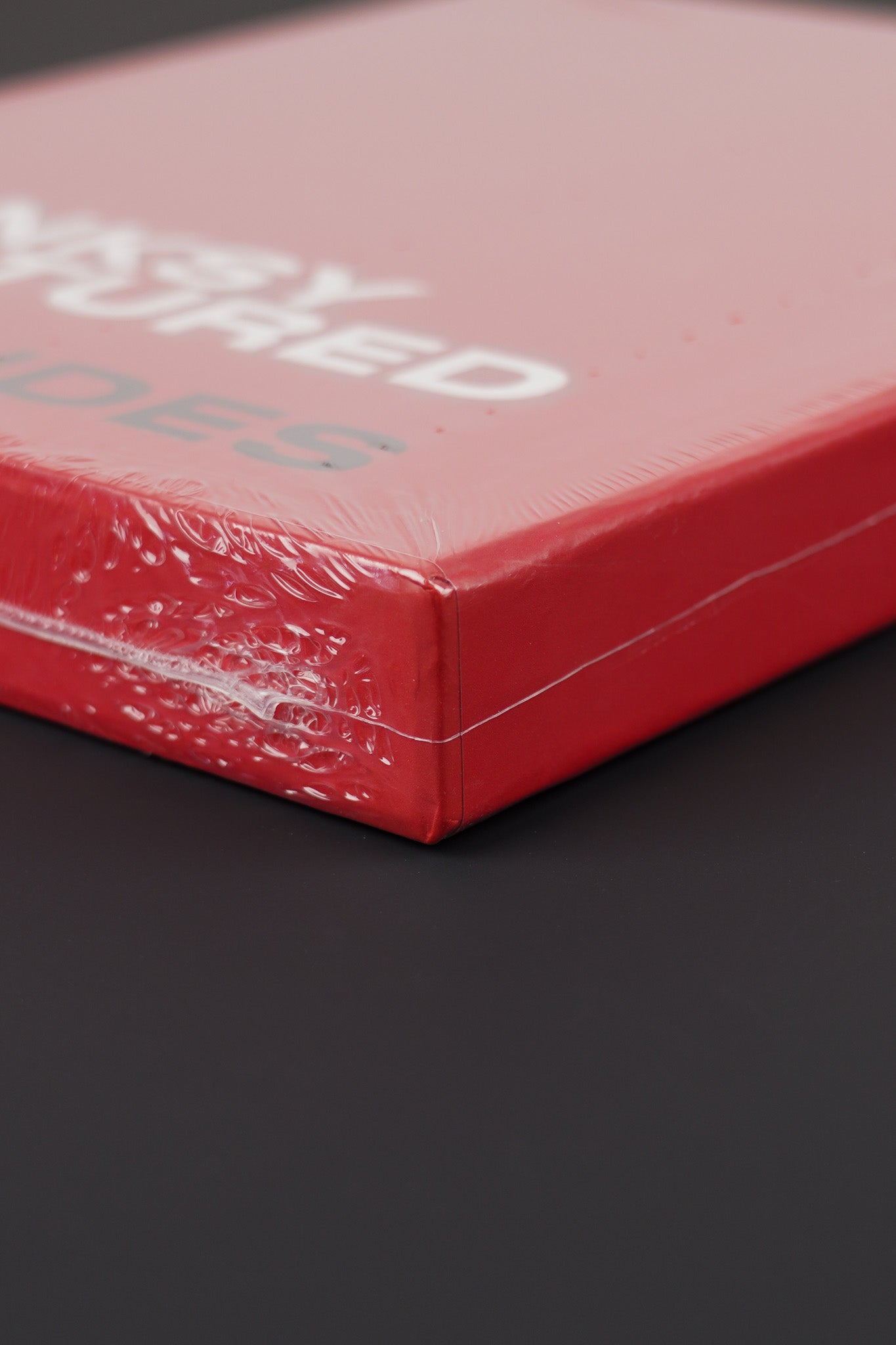 Lower corner detail of the Banksy Captured red hardcover in its slipcase, showing precision in its build.