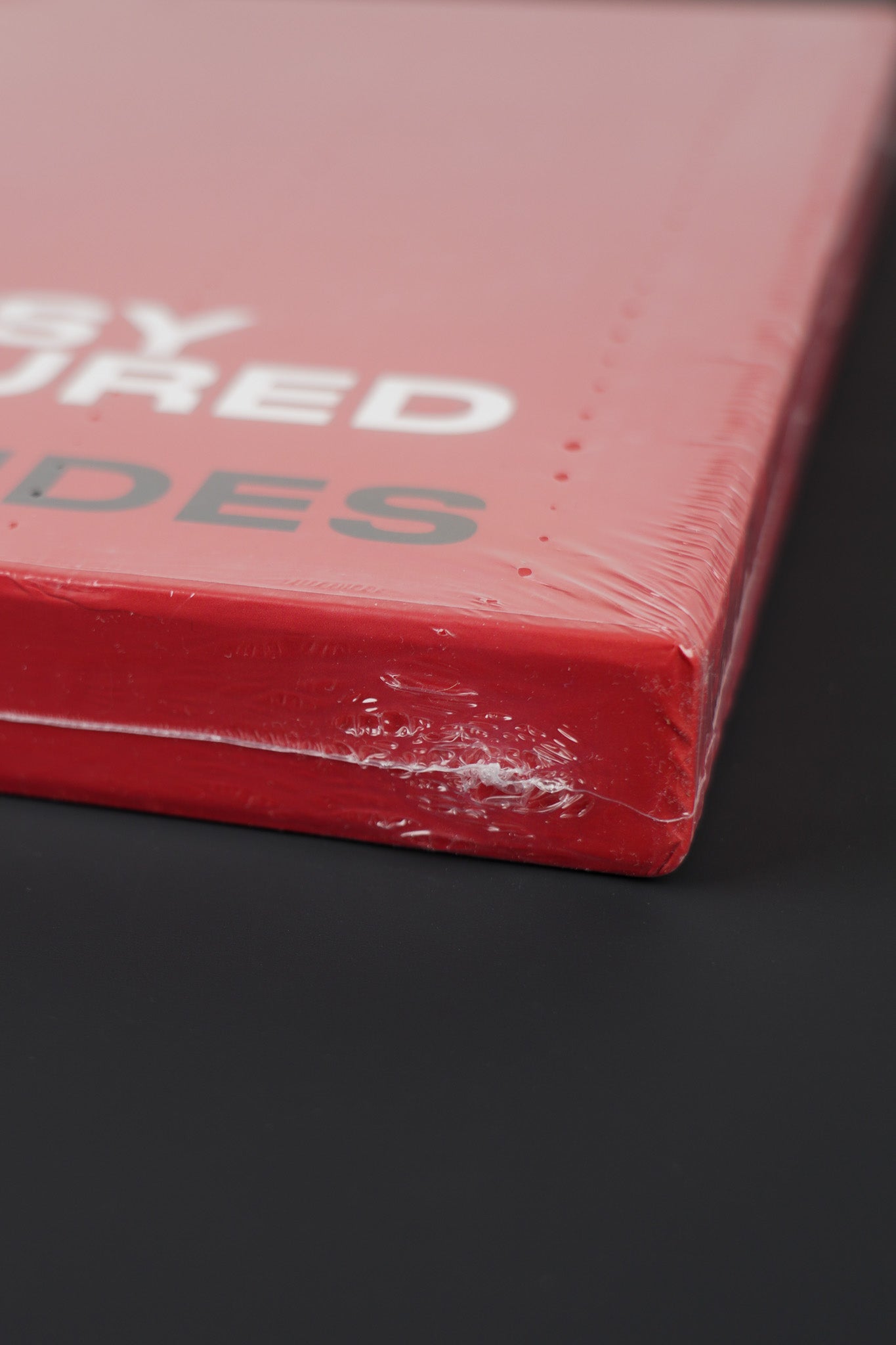 Side view of the Banksy Captured red slipcase, showcasing the intact seal.