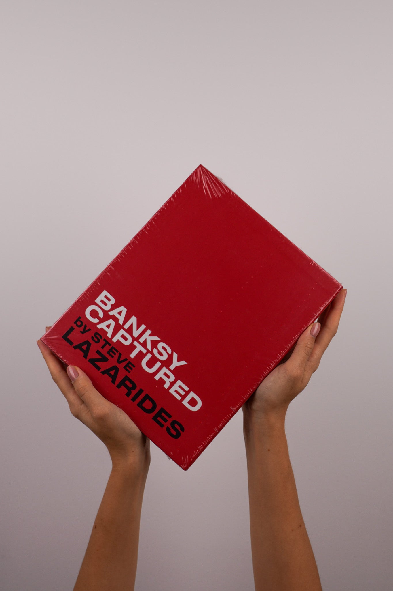 Full view of the Banksy Captured hardcover edition in a vibrant red slipcase, sealed for protection.