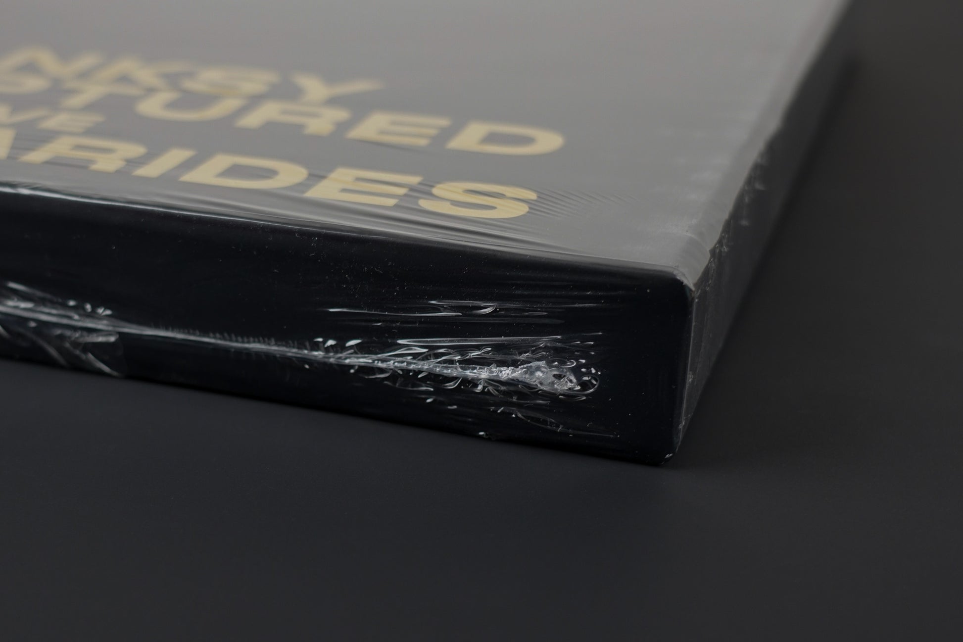 Close-up of the sealed side of the Banksy Captured black edition slipcase, emphasizing its untouched condition.