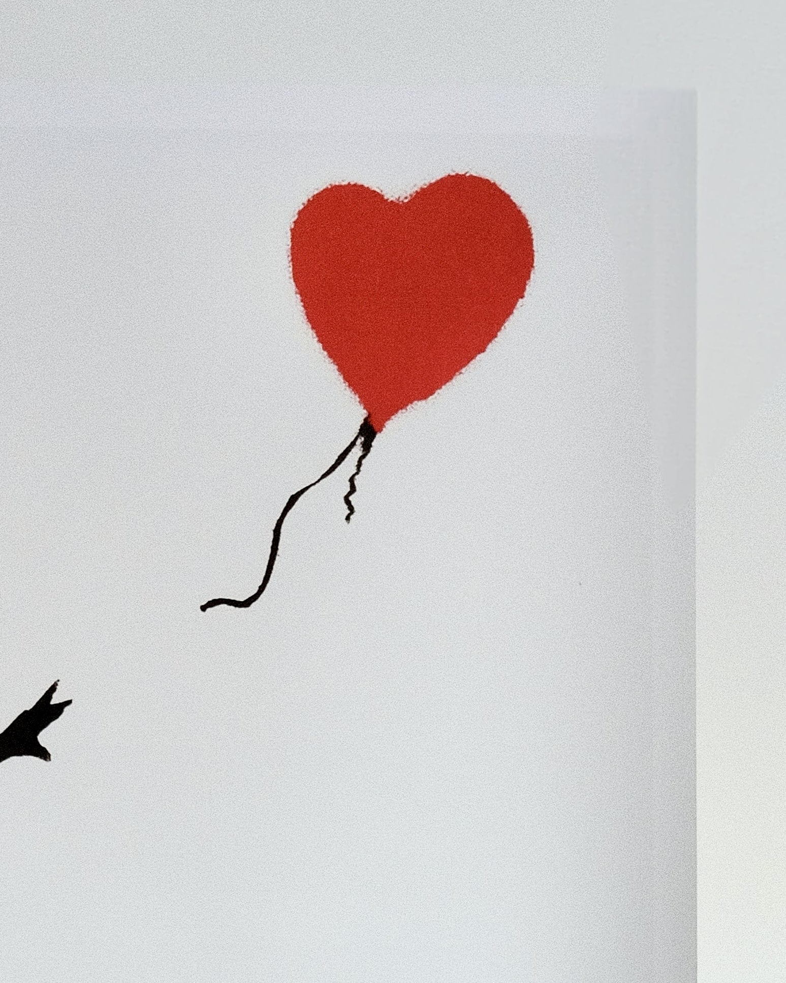 Detailed view of the red heart-shaped balloon in Banksy's 'Girl with Balloon' print, highlighting its vibrant color against the monochrome background.