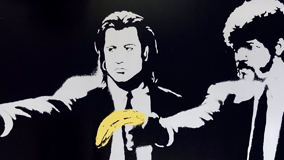 Close-up of the characters holding bananas in Banksy's 'Pulp Fiction' print, emphasizing the clever twist on the iconic scene.