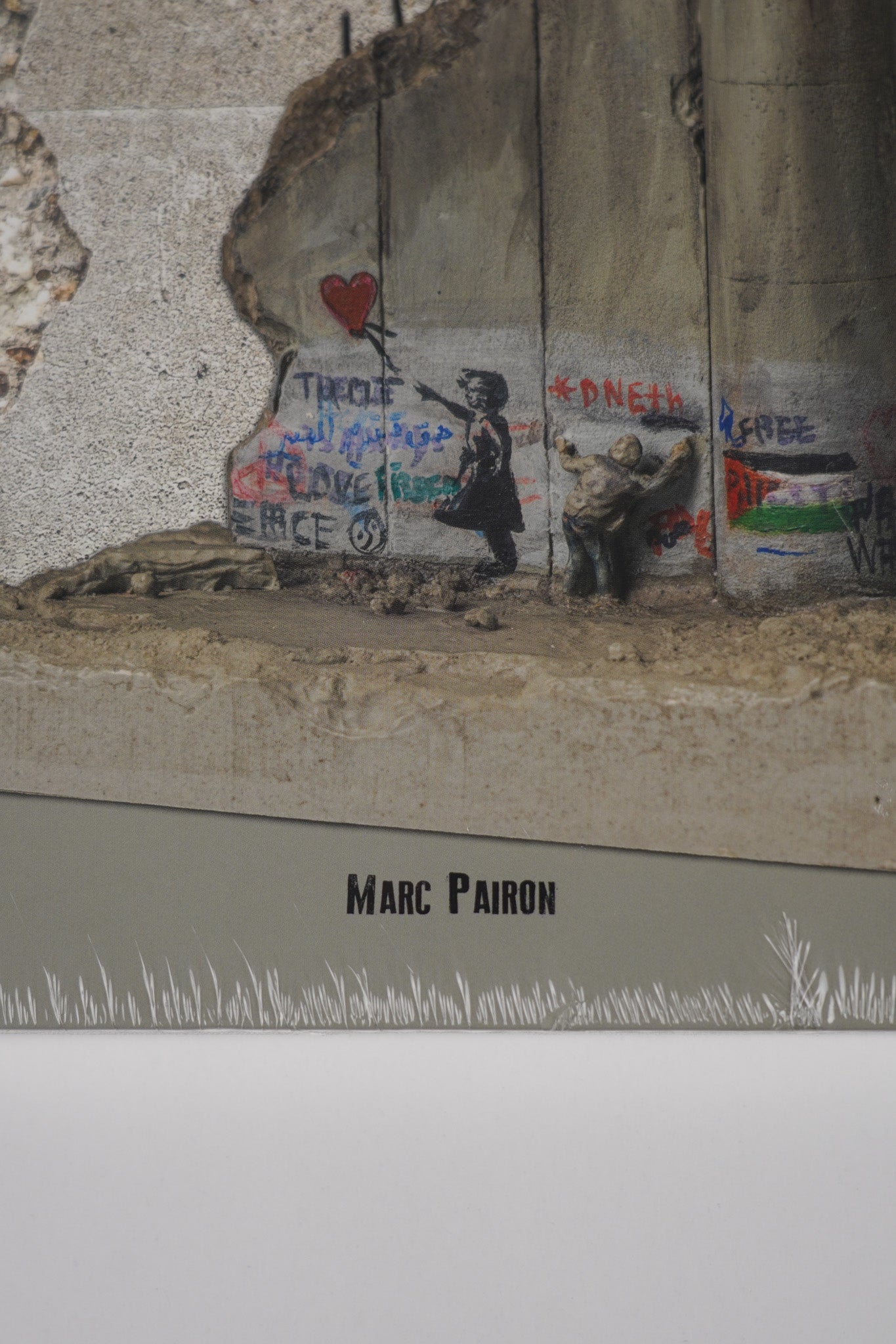 Close-up of Marc Pairon’s name on the front cover of "Banksy: The Walled Off Art Editions Are Sold Out" showing text detail.