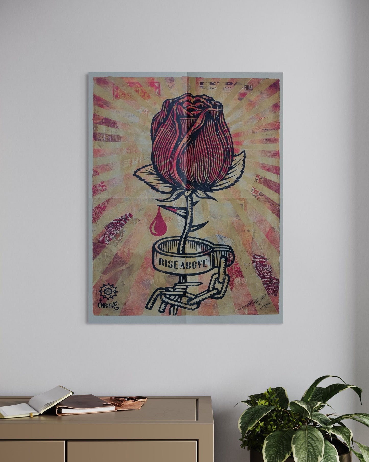 The 'Rise Above' print by Shepard Fairey framed and hanging on a wall, showcasing the rose in a chain with striking detail and vibrant colors.