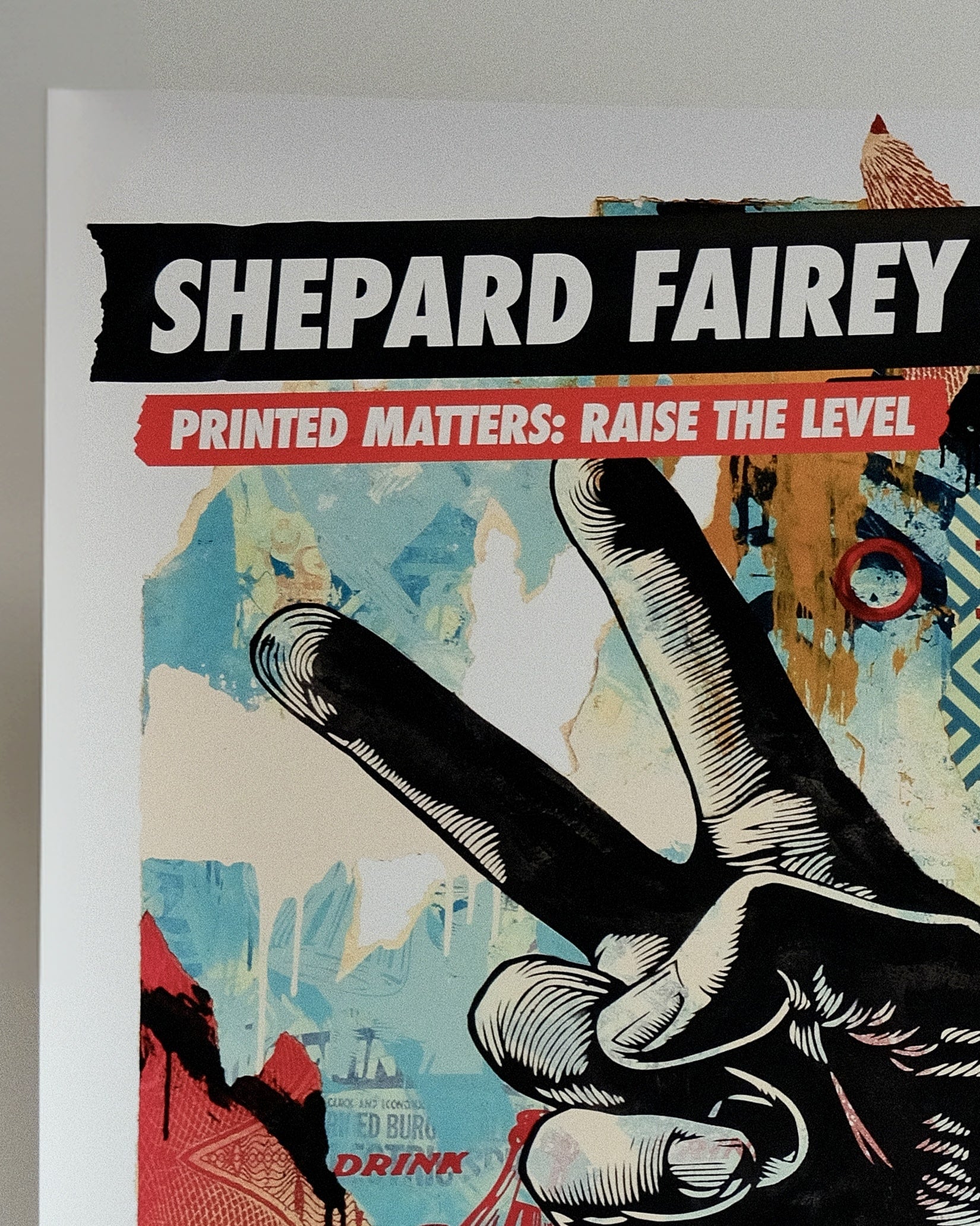 Close-up of the vibrant colors and bold typography in Shepard Fairey's 'Printed Matters: Raise the Level' print.