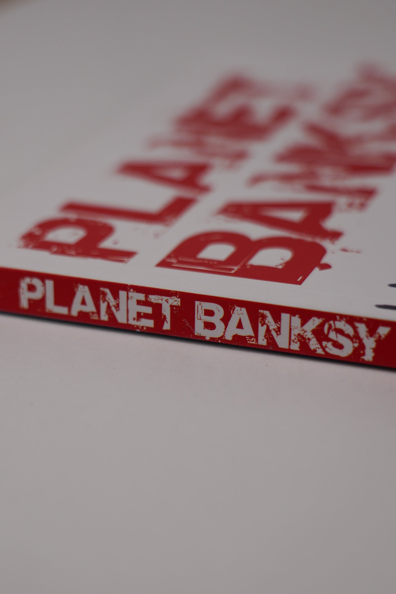 Spine of "Planet Banksy" displaying the book title and graffiti-inspired typography.